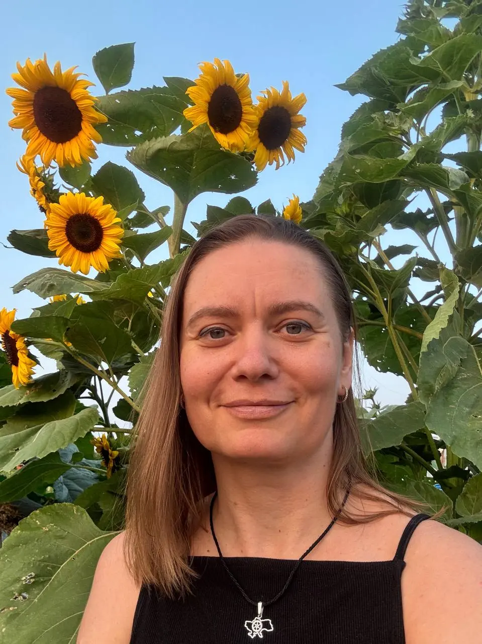 Olga Ialovenko among sunflowers at a community gathering