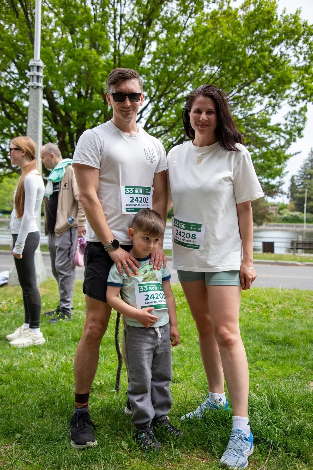 Une famille de trois personnes portant des dossards de la Chestnut Run sur la pelouse avant le départ