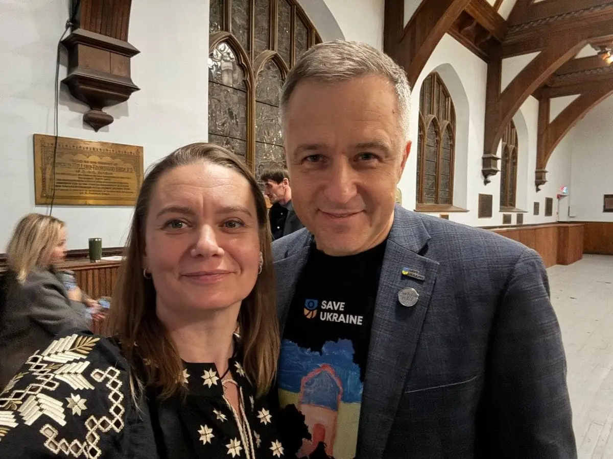 Two community members taking a selfie indoors, one wearing a Save Ukraine t-shirt under a blazer, the other an embroidered blouse
