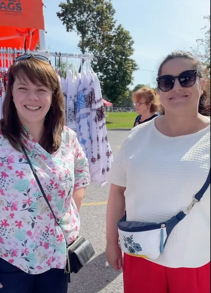 Two women walking together through the festival crowd at UAFest