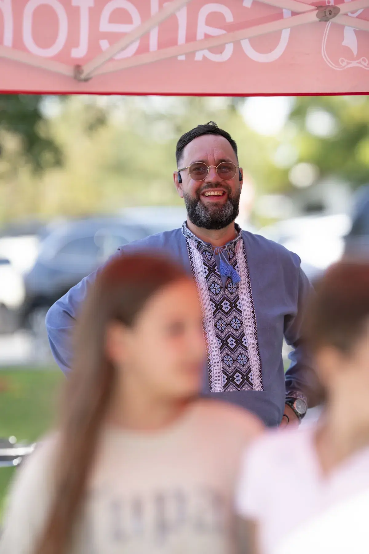 Maksym Stepanenko at UAFest 2026 — Smiling man in an embroidered shirt at a food tent (photo: Tim Skinner)