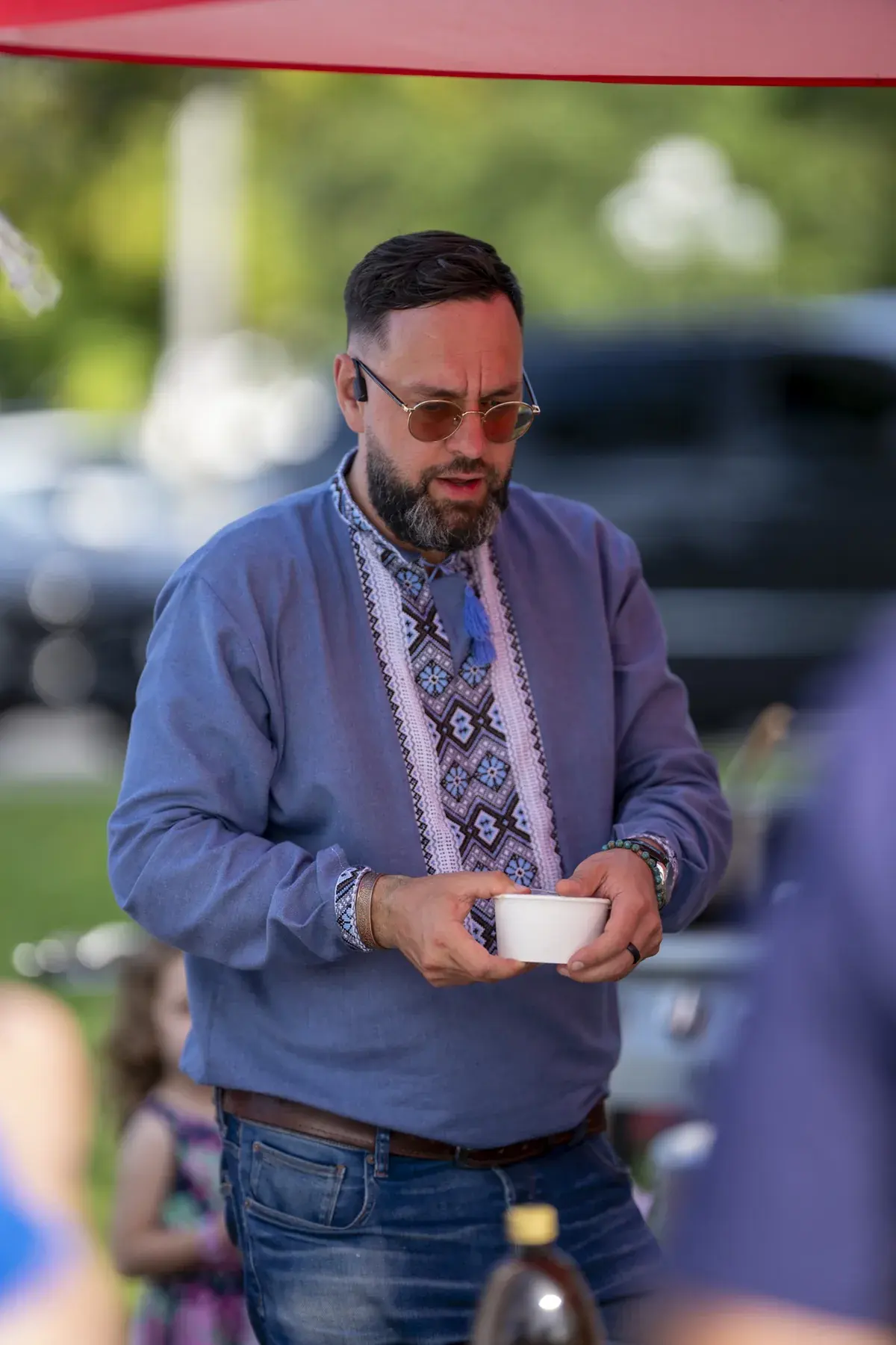 Maksym Stepanenko at UAFest 2026 — Man in an embroidered shirt holds a bowl of food (photo: Tim Skinner)