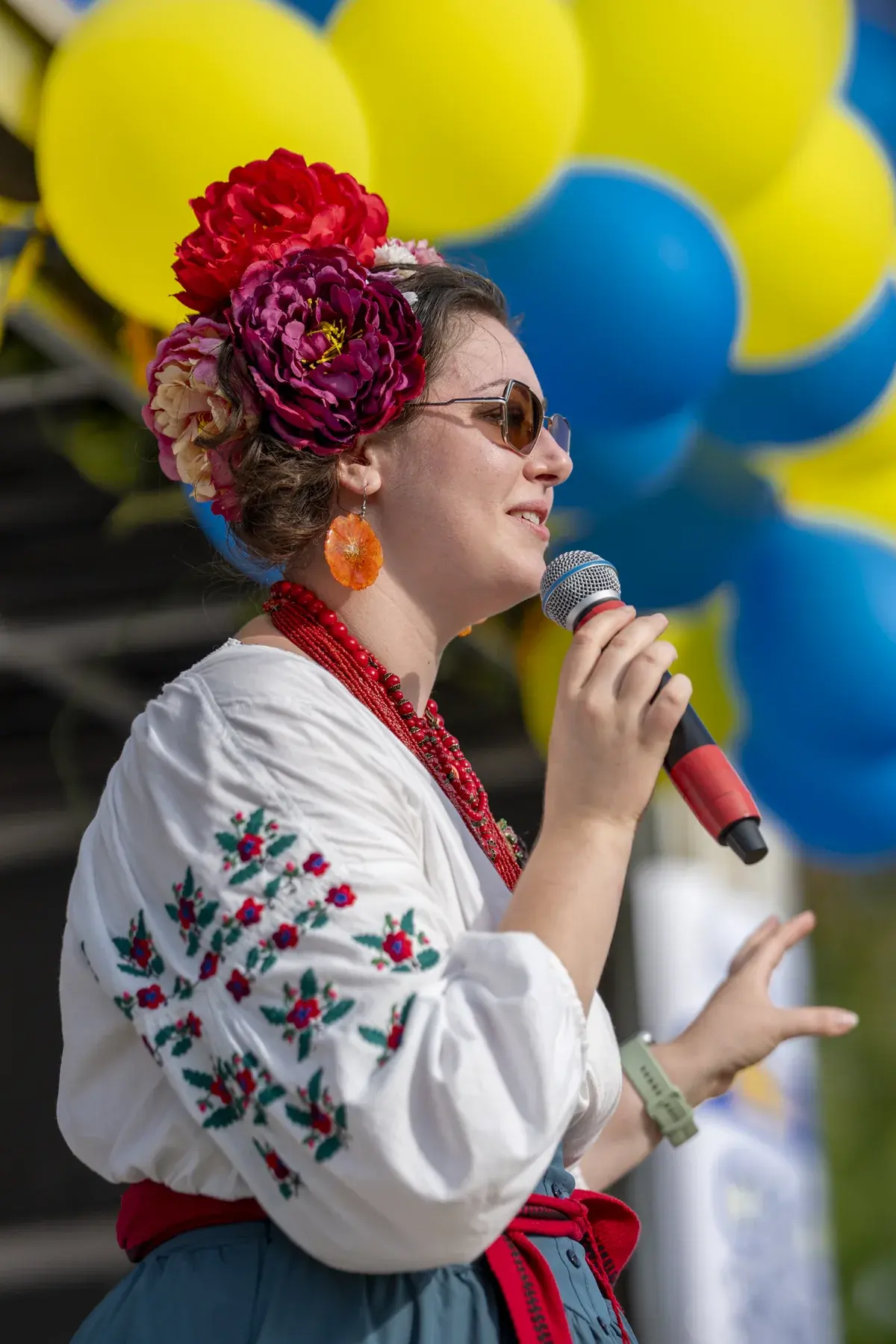 Olga Ostafiichuk at UAFest 2026 — Host in a floral crown singing among blue and yellow balloons (photo: Tim Skinner)