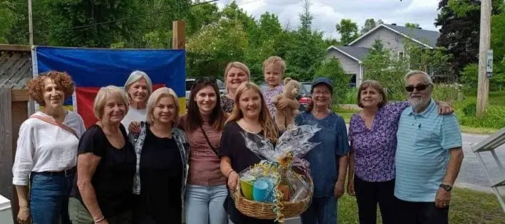 Group photo at an outdoor community garage-sale fundraiser event that helped launch UAFest