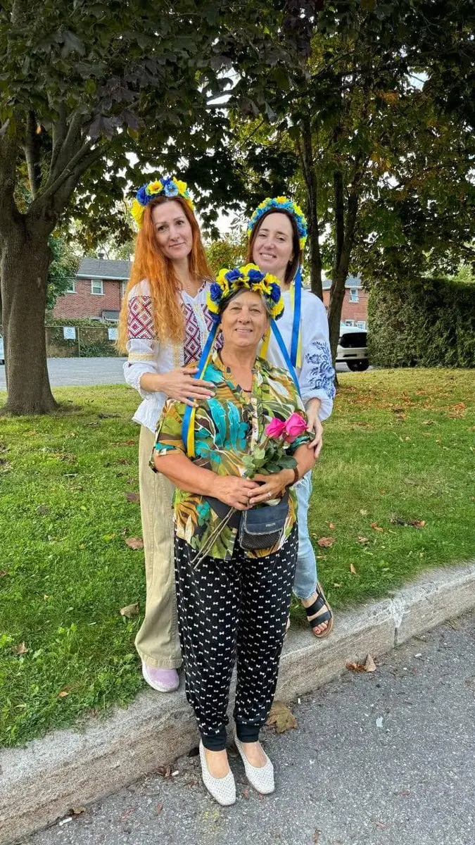 Three women in traditional Ukrainian flower crowns posing together at UAFest
