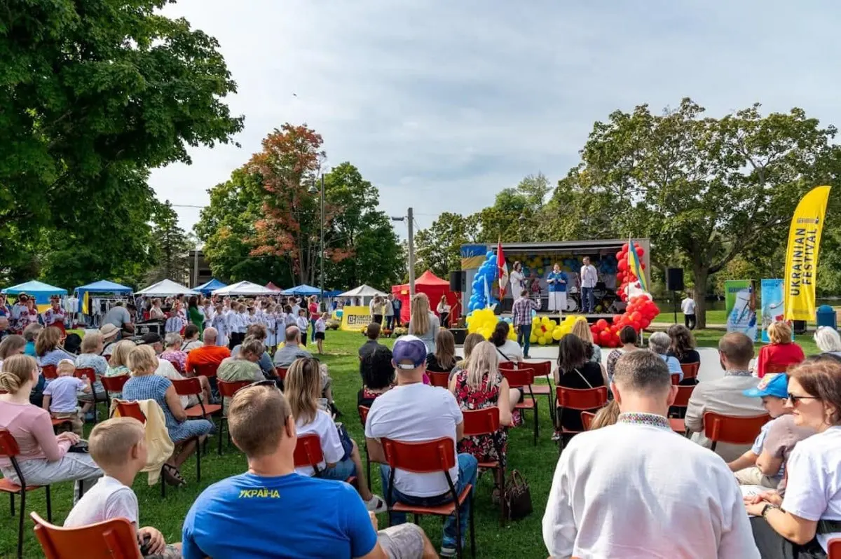 Man hosting the festival programme at the microphone against a blue-and-yellow UAFest stage backdrop