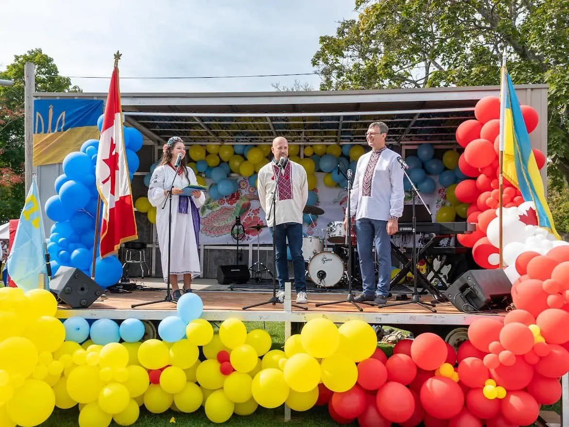Festival host speaking outdoors with a microphone at UAFest