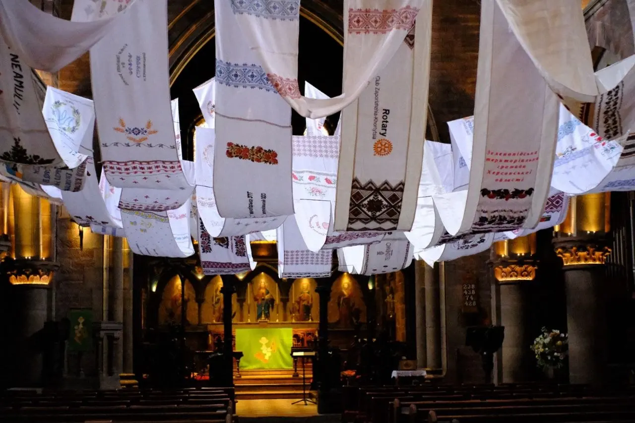 Close view of individually embroidered rushnyk panels, one reading Rotary Club