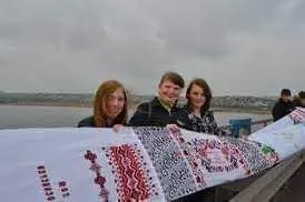 Cadets and volunteers unrolling the original rushnyk across the Antonivskyi Bridge in Kherson, 2014