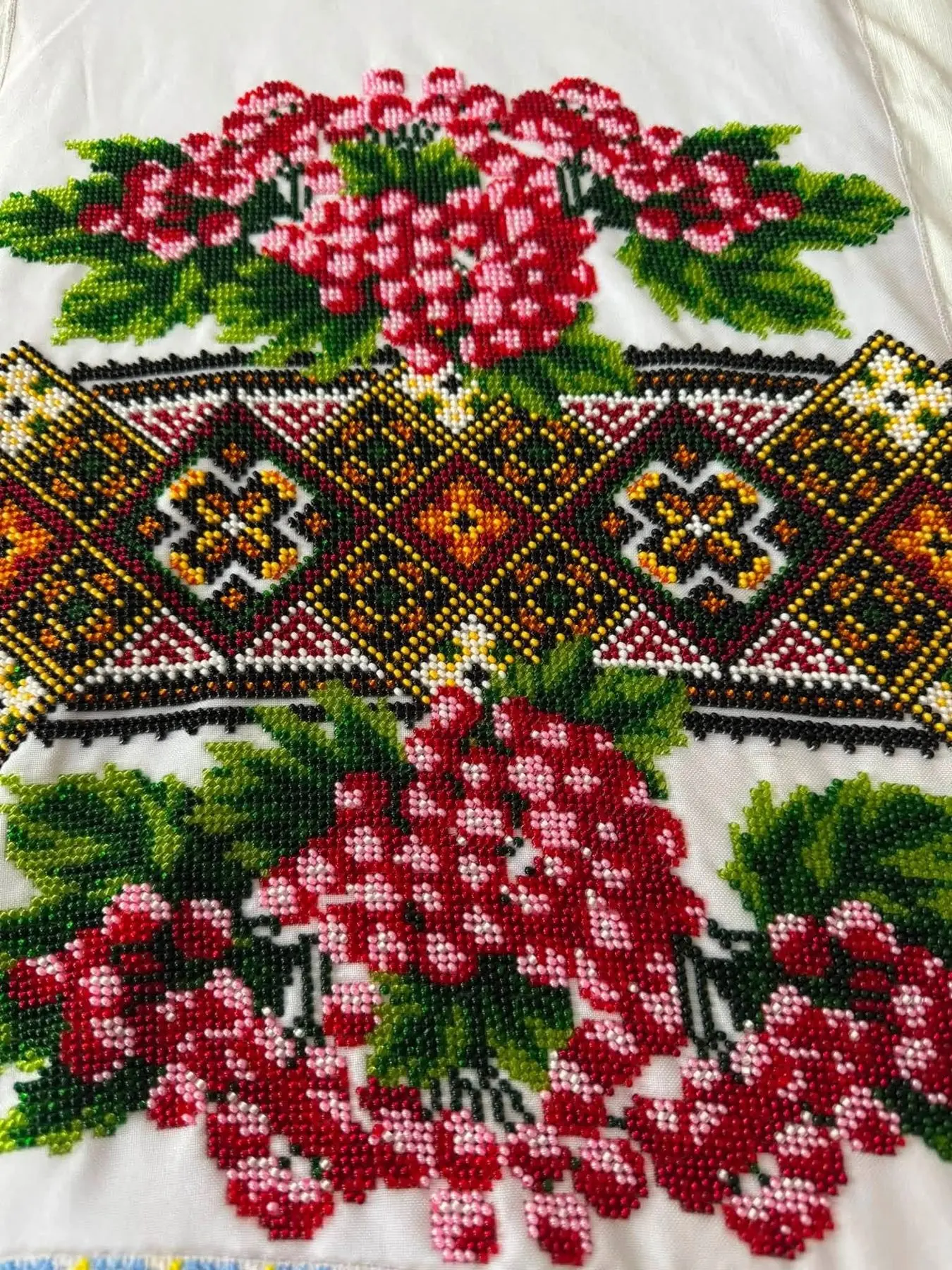 Close view of a beaded panel with kalyna berries around a geometric star