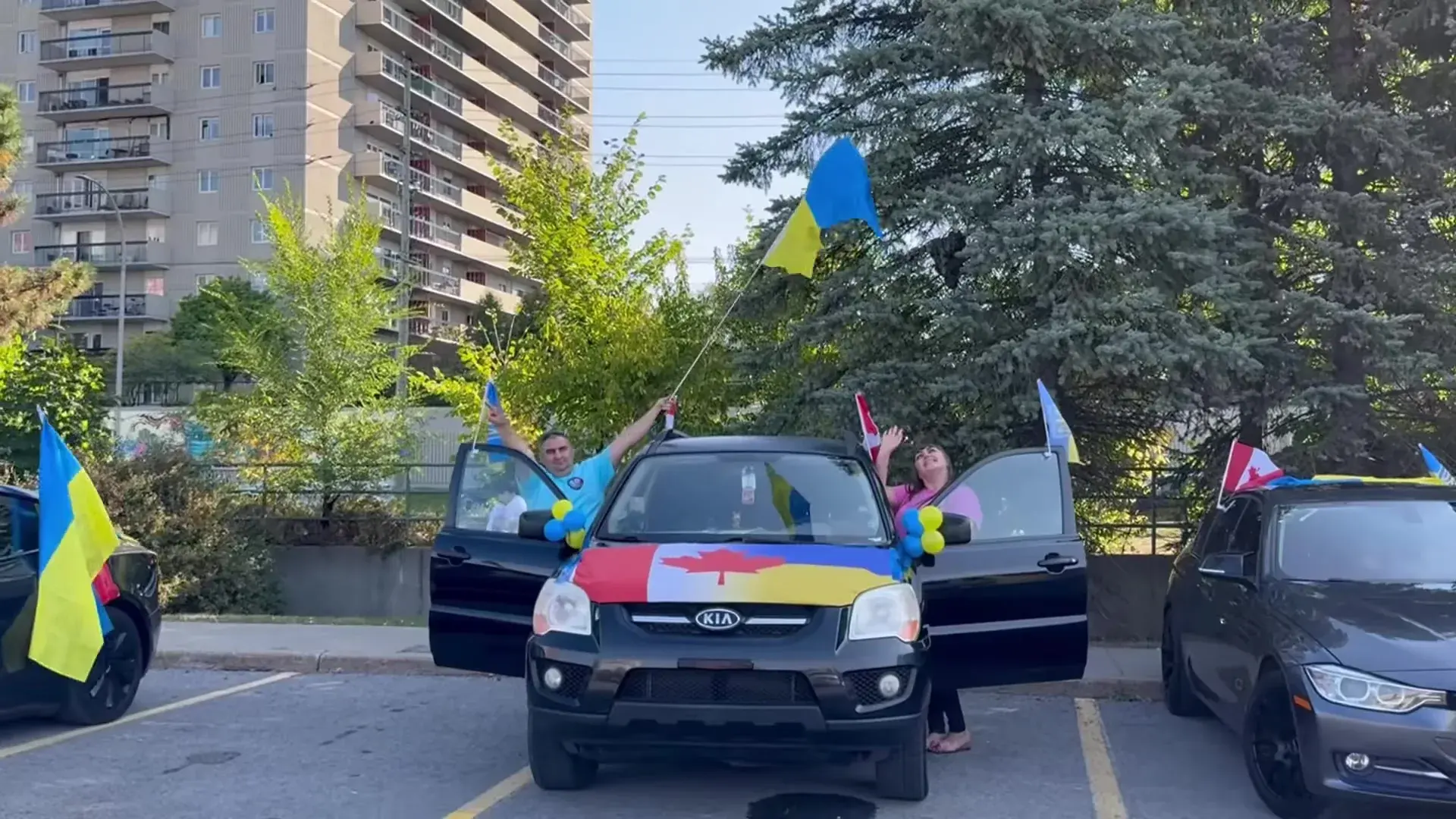 Український прапор піднімають над авто, розмальованим у кольори України та Канади, поки колона UAFest 2024 збирається в Оттаві