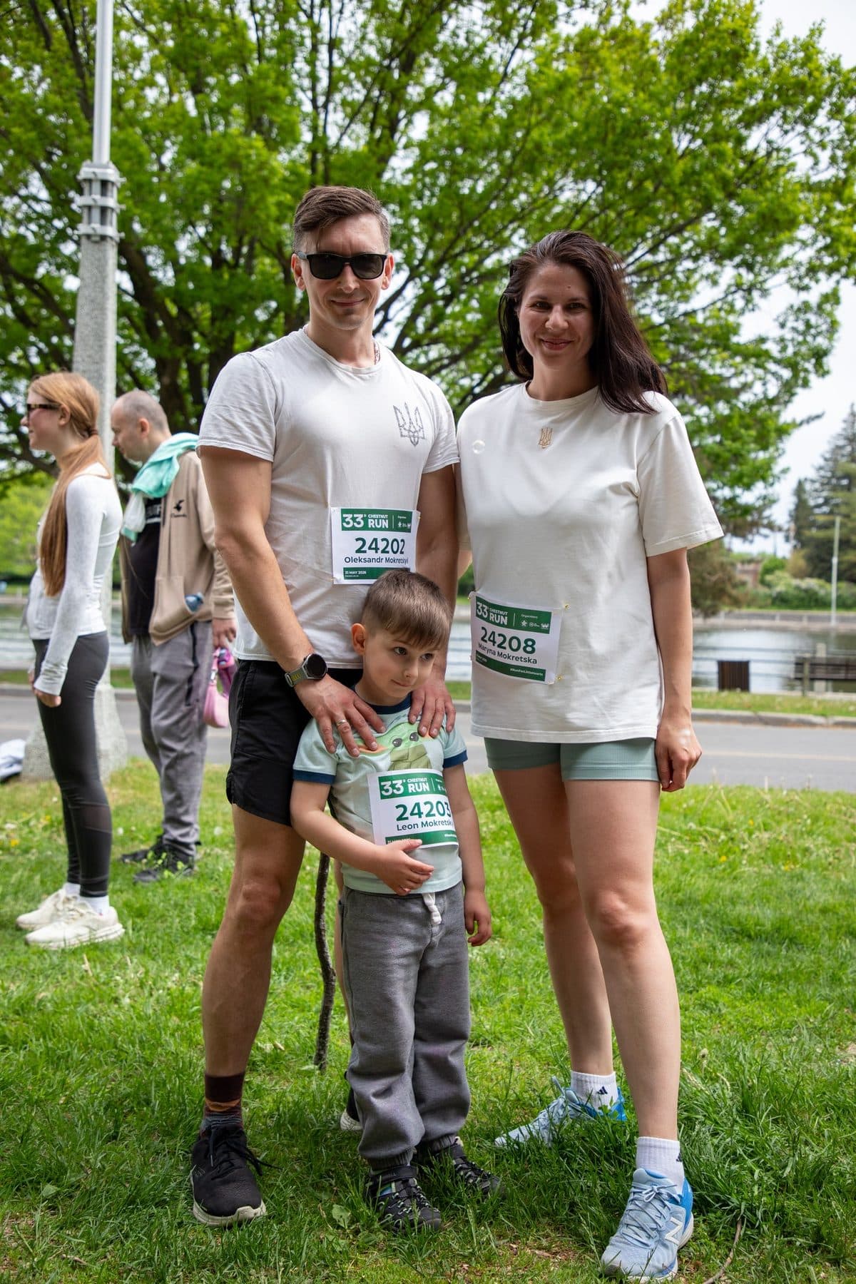 Une famille de trois personnes portant des dossards de la Chestnut Run sur la pelouse avant le départ