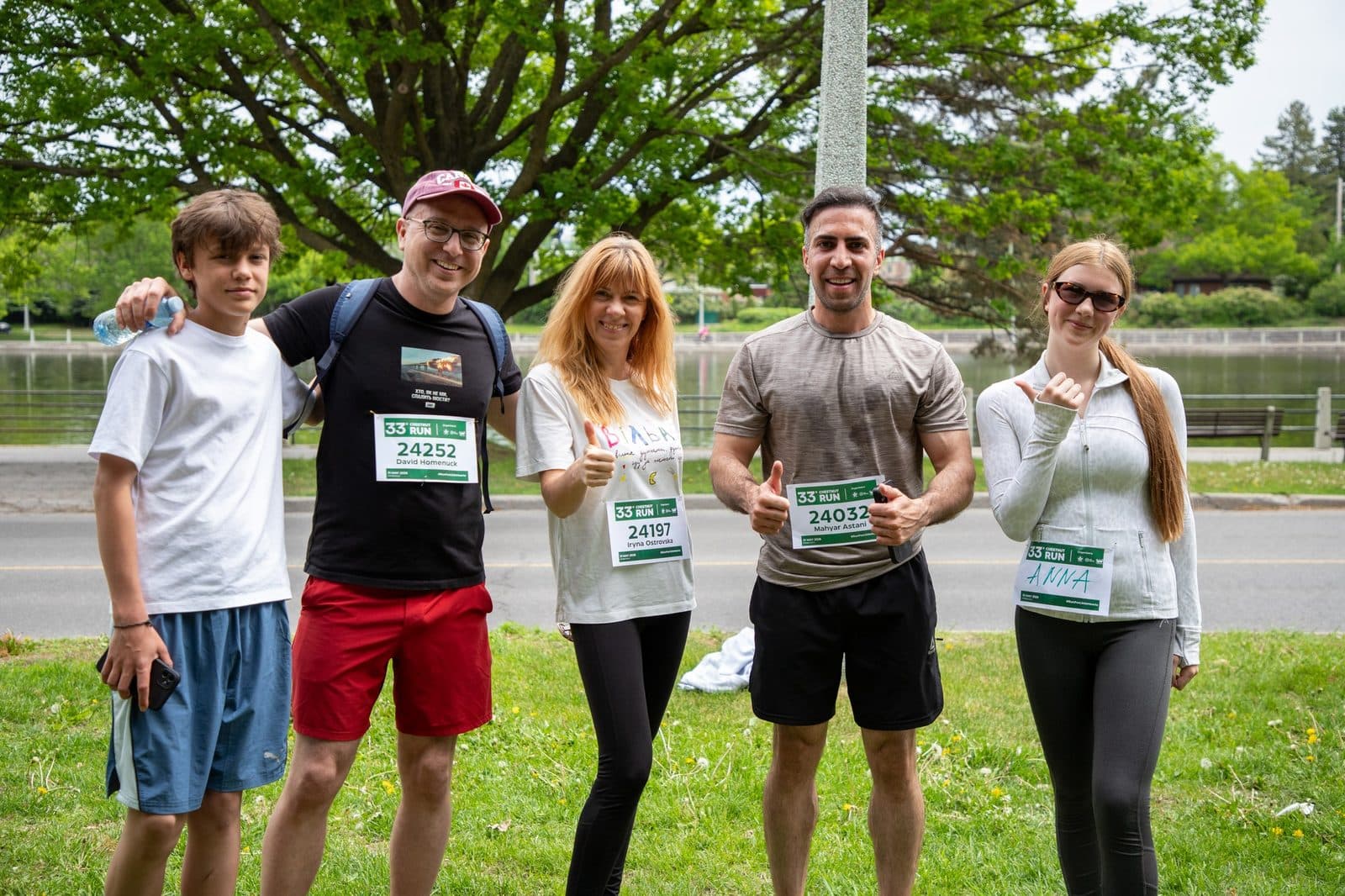 Un groupe de participants de la Chestnut Run portant leur dossard, rassemblés au bord de l’eau à Ottawa avant le départ