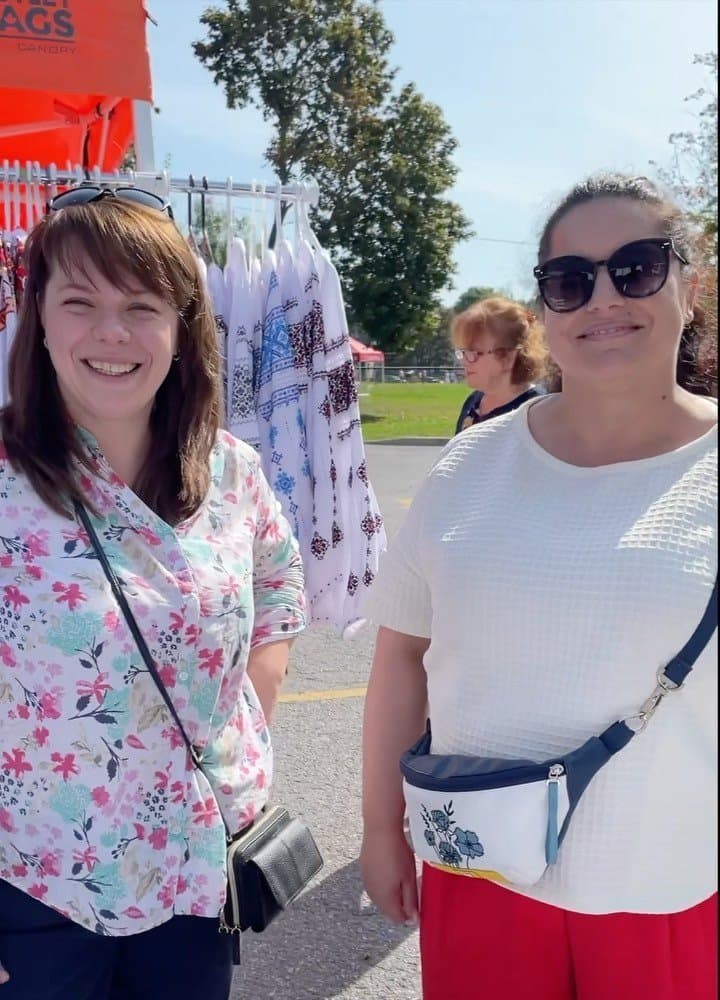 Two women walking together through the festival crowd at UAFest