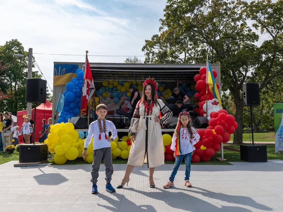 Children in embroidered vyshyvanka shirts in front of a giant Ukraine flag held by the crowd — the next UAFest generation