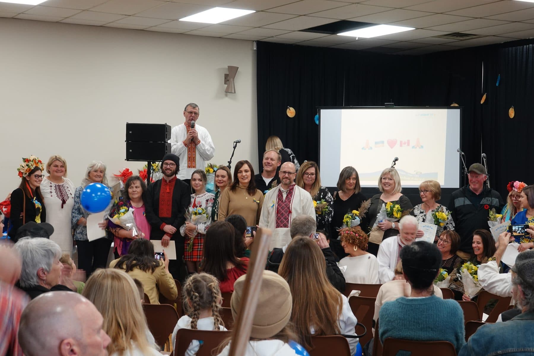 Organisateurs, bénévoles et partenaires communautaires d’Ukrainian Fest Lanark County réunis lors d’une fête communautaire, fleurs et certificats à la main