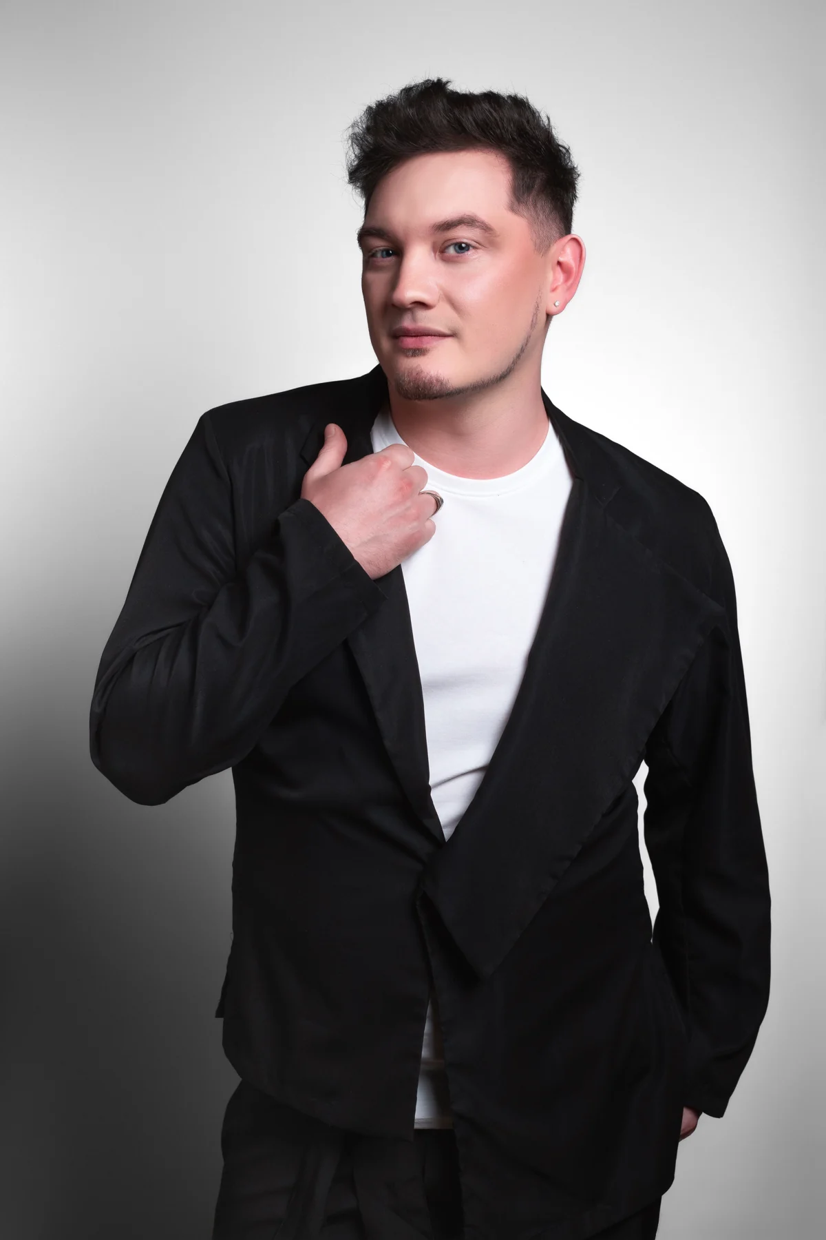 Studio portrait of DEN BAURIN in a black jacket over a white t-shirt, from the "2026 — New Season" gallery on his own site