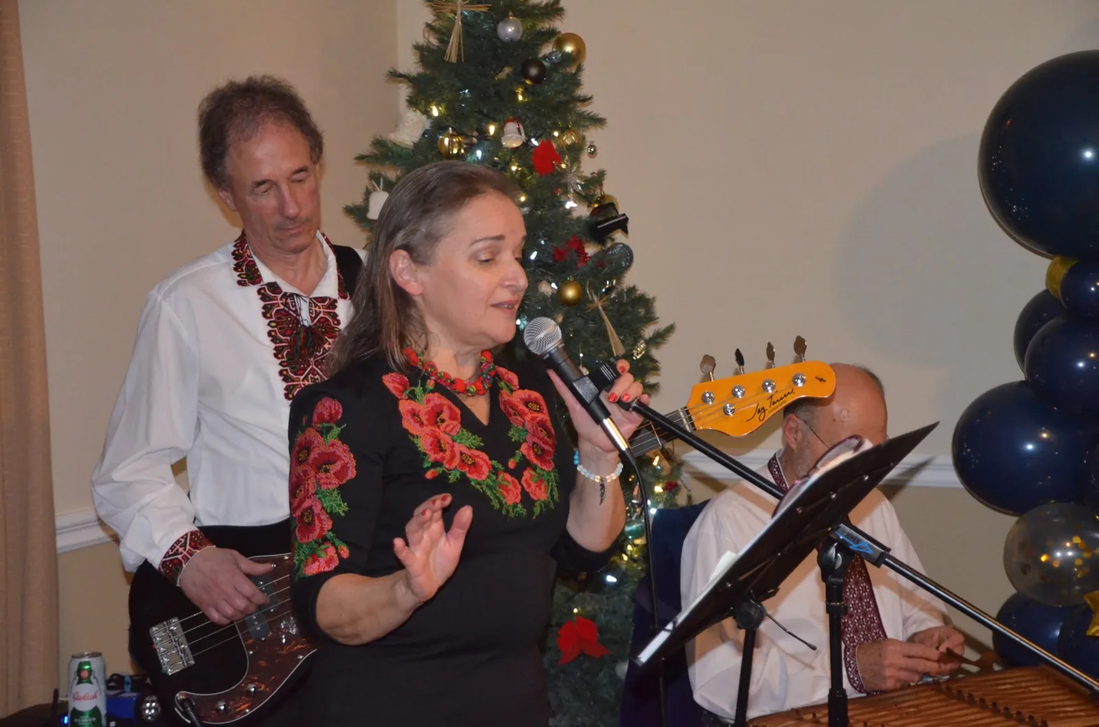 Olya singing in front of a Christmas tree