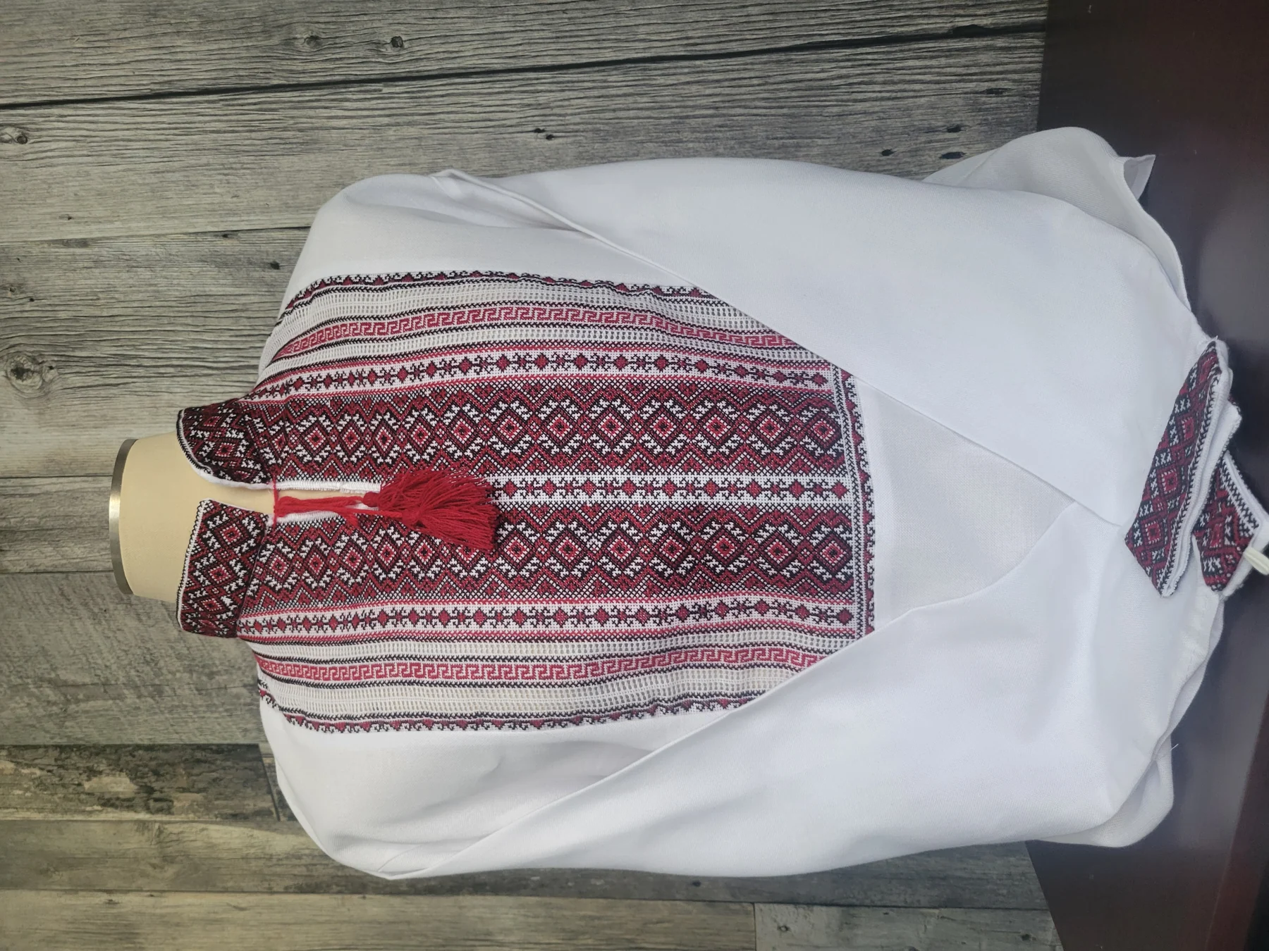 "Козацька Сила" — a white men's vyshyvanka with red-and-black hand embroidery and a red tassel tie