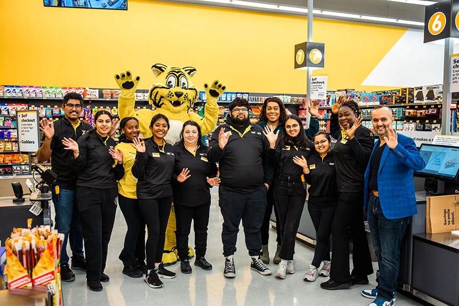 Giant Tiger staff members posing in store with the Friendly mascot