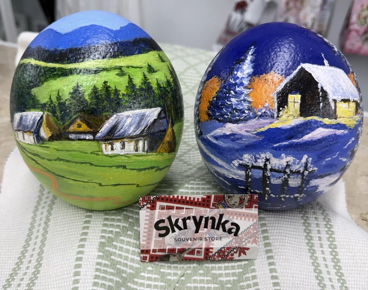 Two hand-painted ostrich eggs photographed with a Skrynka business card