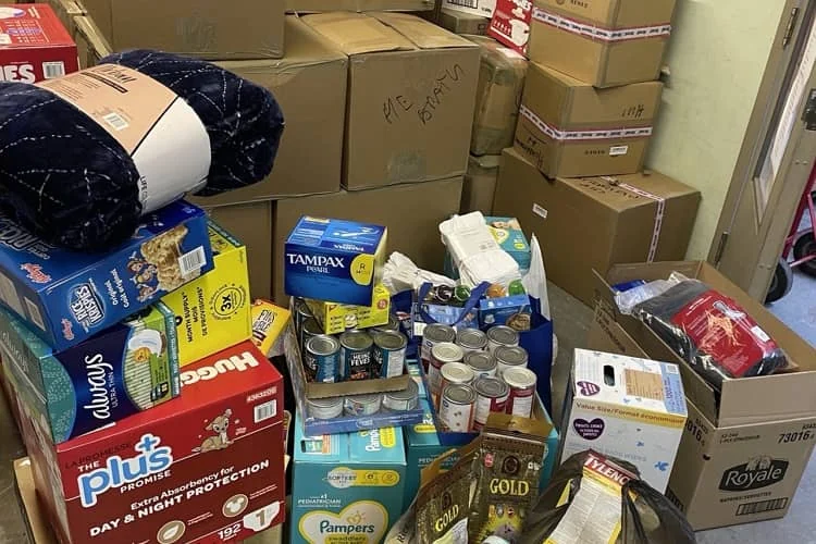 Boxes of nappies, tinned food, hygiene products and a folded blanket piled up for shipping to Ukraine