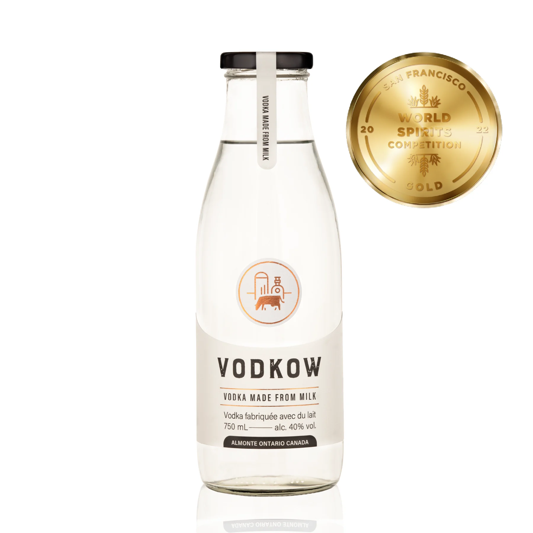 A 750 mL bottle of Vodkow Vodka shaped like a milk bottle, labelled "vodka made from milk", 40% alc., Almonte Ontario Canada, beside the gold medal of the 2022 San Francisco World Spirits Competition