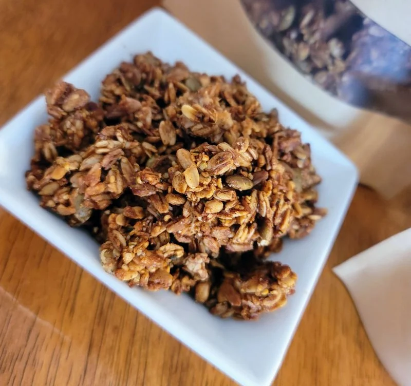 Maple crunch granola in a white dish on a wooden table — gluten-free, vegan, soy free
