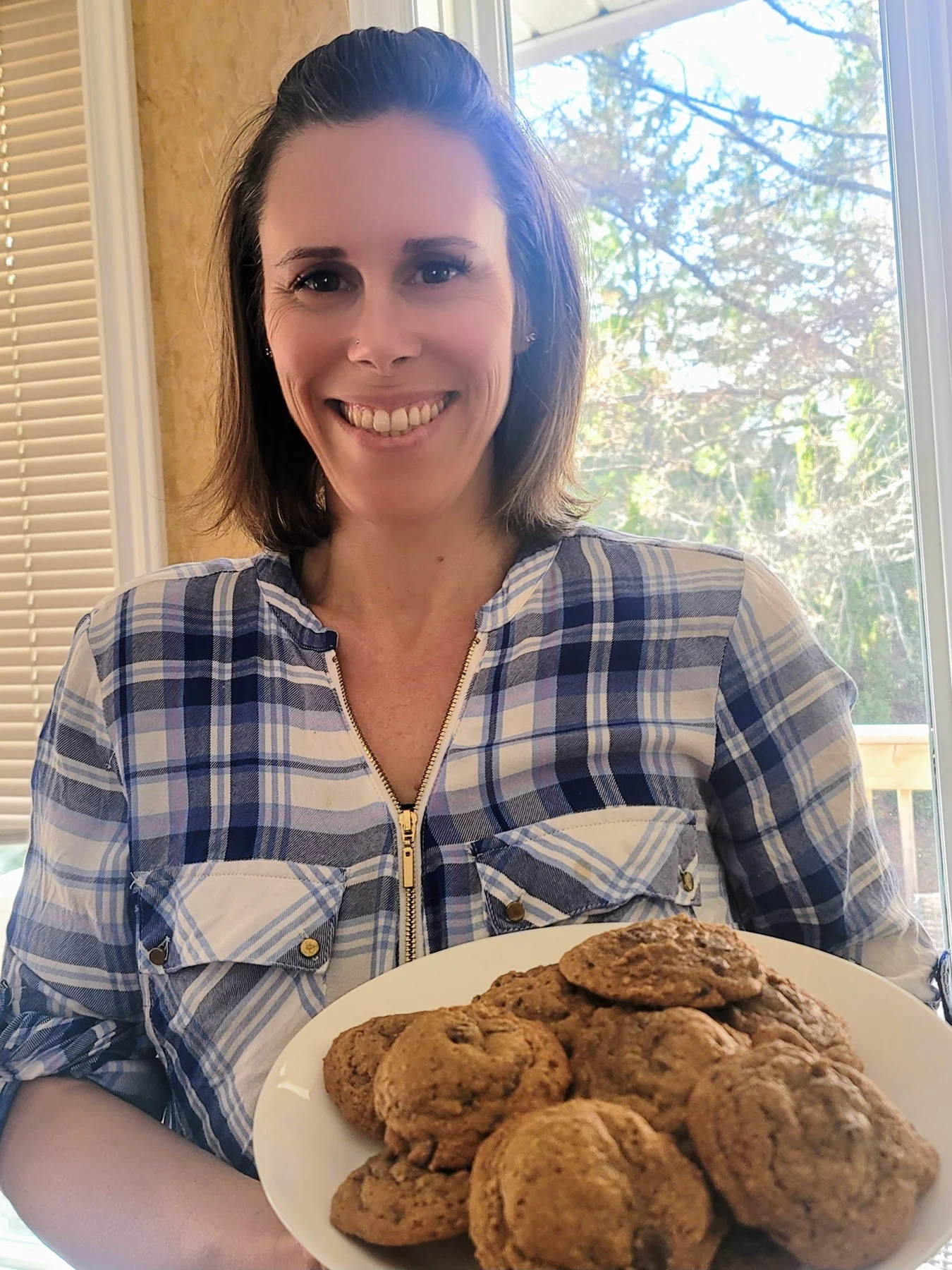 Christy Rushton holding a white plate of freshly baked cookies